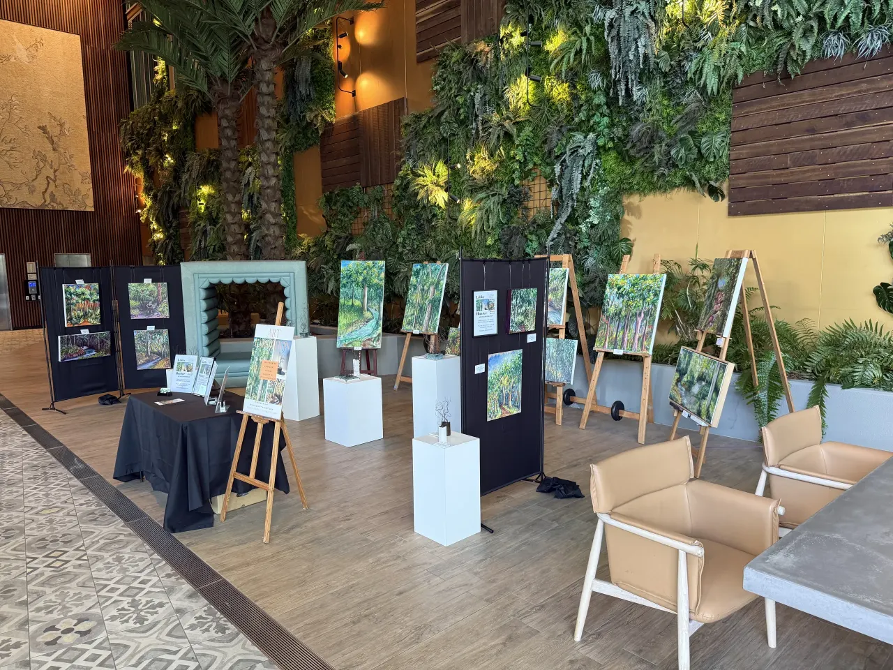 Art exhibition among palms and planted walls in the lobby
