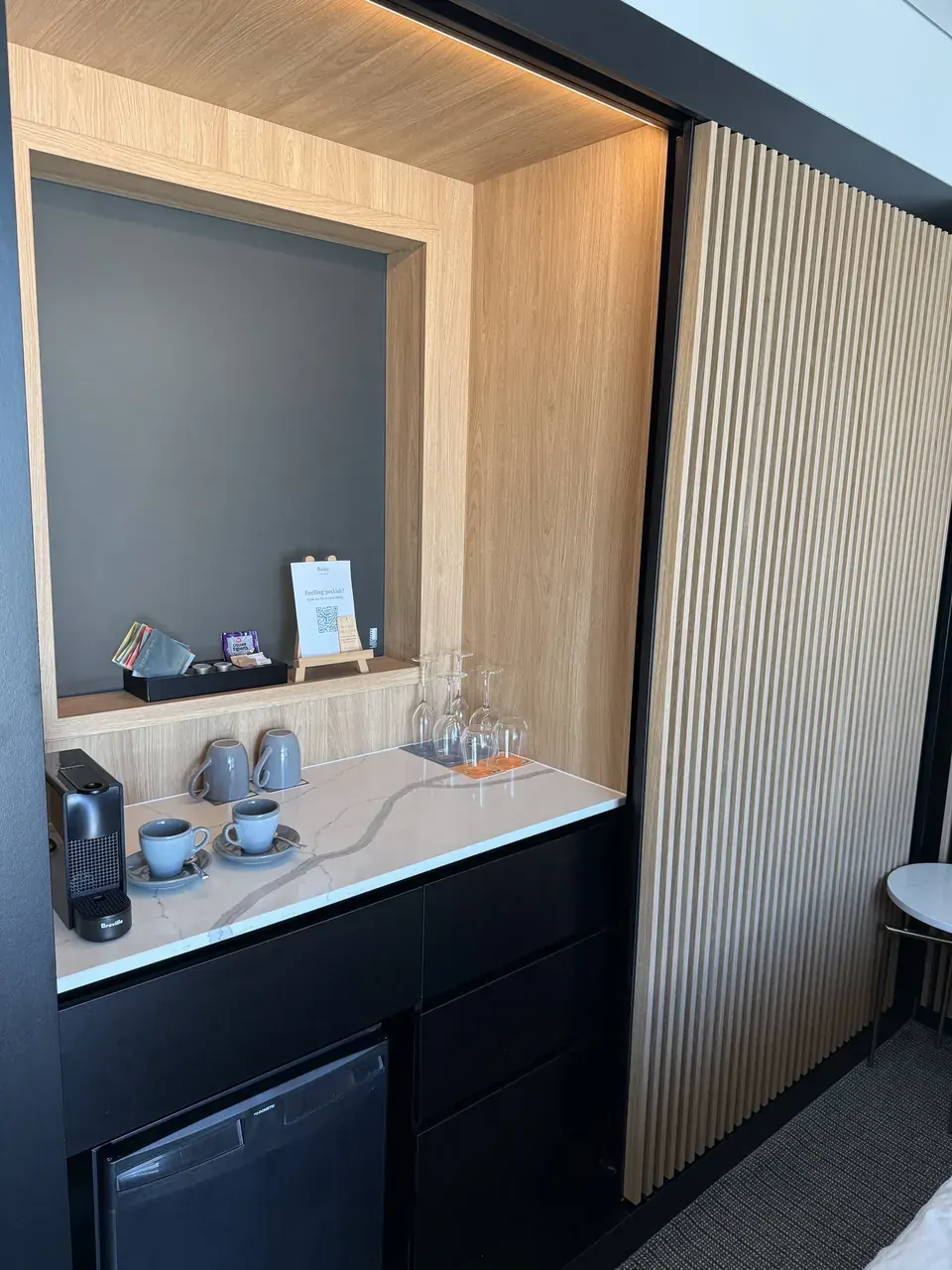 The coffee station, cups and minibar in the room