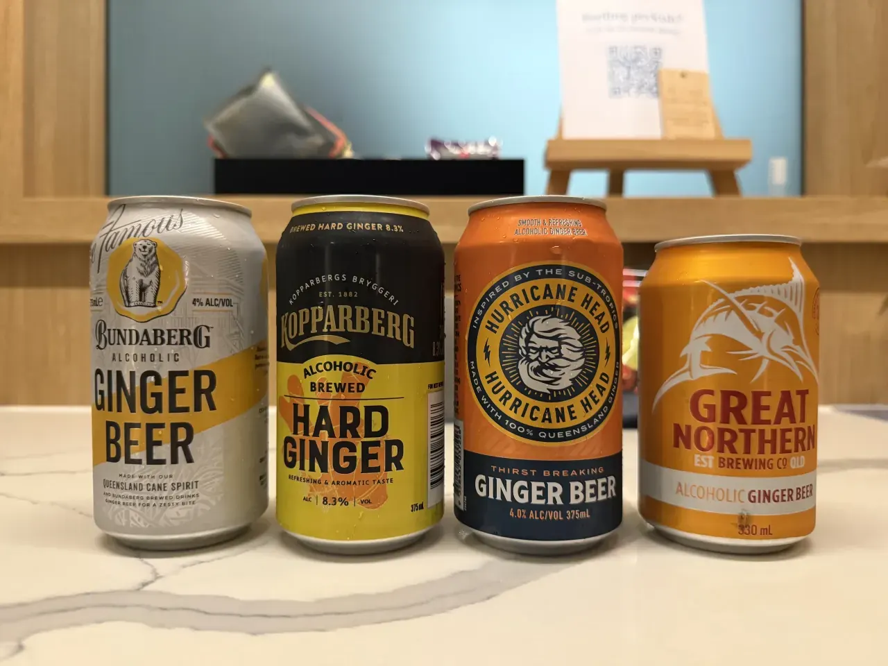 Four cans of alcoholic ginger beer on the hotel counter