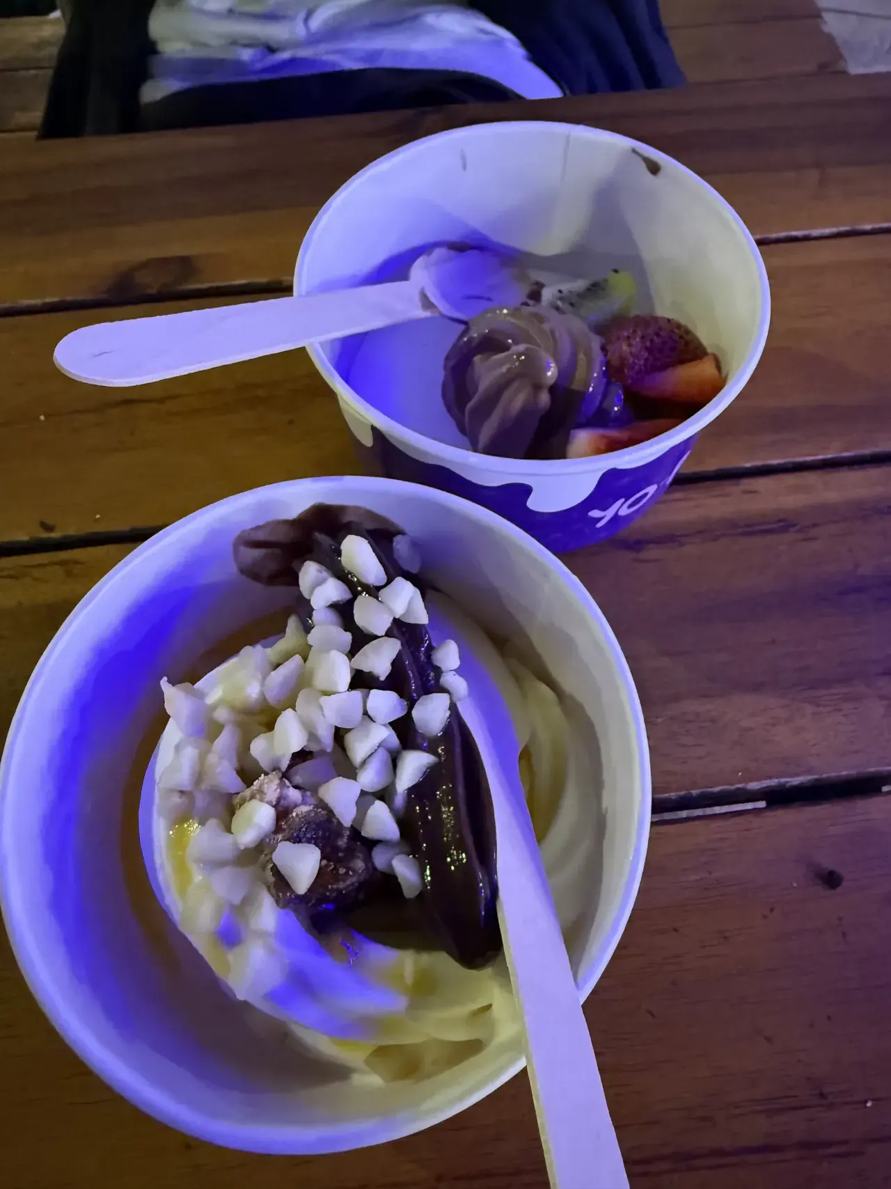 Frozen yoghurt bowls with toppings under the festival lights